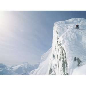  A Mountain Climber Scrambles up a Steep, Rime Covered 